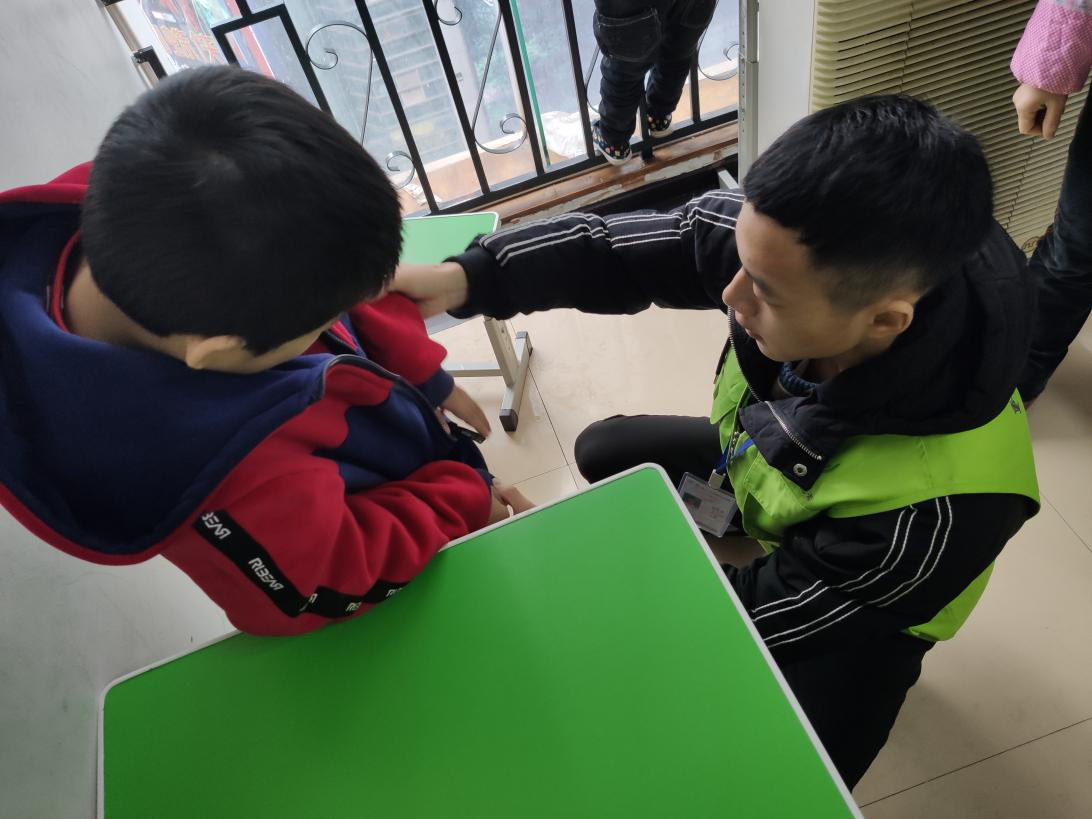志愿者教小朋友拉拉链